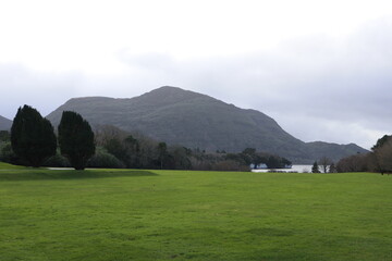 landscape with lake, clouds and mountains with green grass near Muckross House. The National Park, Dromyrourk, Killarney, Co. Kerry, Ireland