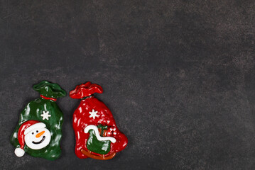 Fototapeta na wymiar Two bags of Santa Claus with gifts. Christmas sweets covered with colored icing sugar. Dark gray background. Top view. Copy space