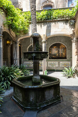 Fototapeta na wymiar The inner courtyard with a fountain in Casa de l’Ardiaca, a medieval historic house hosting a city archive of Barcelona
