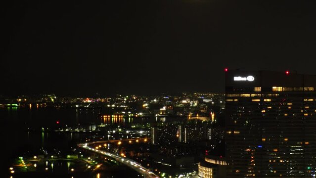 FUKUOKA, JAPAN - NOV 2022 : Aerial high angle view of Fukuoka City and full moon. Time lapse shot at night. View around Tenjin and Nakasu downtown area. Travel and urban city nightlife concept video.