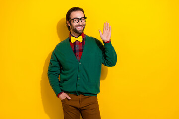 Photo of positive neat person toothy smile arm palm waving hi empty space isolated on yellow color background © deagreez