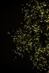 Closeup of Christmas and New Year tree with light. Christmas tree decorated with with icicles,golden balls, garlands. Holiday background