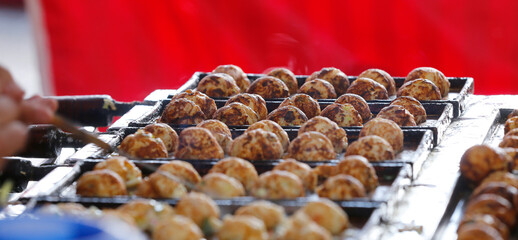 Process to cooking Takoyaki on hot pan. Japanese food on liberdade neighborhood street food In Sao...