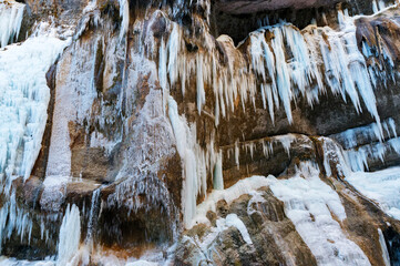 Fototapeta na wymiar A frozen waterfall with ice in a blue and white color in winter