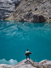 Man opening hands in the turquoise lagoon, mountains of Peru South America