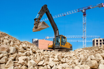 Excavator at construction site. Mountain of small stones with excavator on top. Preparation of site...