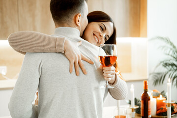 Young couple in love drinking red wine in house kitchen