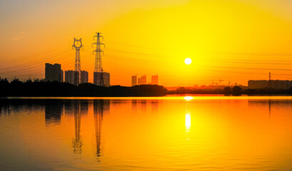 High voltage power lines across the lake at sunset.