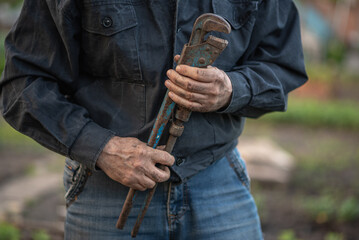 man holding an old pipe wrench