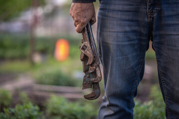 man plumber holding old pipe wrenches