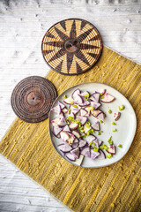 Yellow handwoven textured mat with radishes, onions, potatoes, and peppers - healthy vegan and vegetarian lifestyle food styling