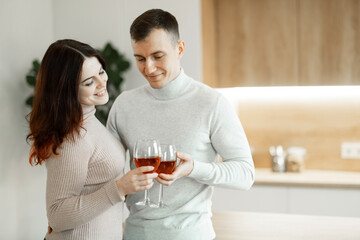 happy married guy husband and wife drinking red wine celebrate together at home