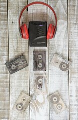 personal stereo, audífonos y cassette sobre madera blanca envejecida