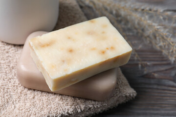Soap bars and terry towels on wooden table, closeup