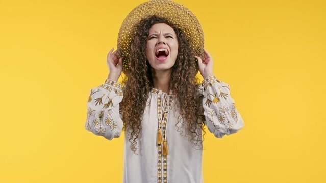 Ukrainian furious woman shouting on yellow background. Lady in stress and rage, she threatens with aggression and looking at camera.