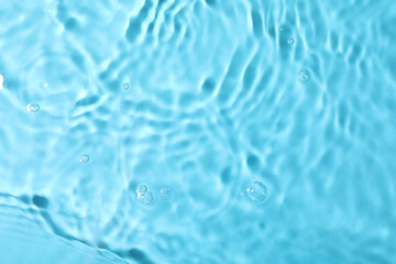 Closeup view of water with rippled surface on light blue background