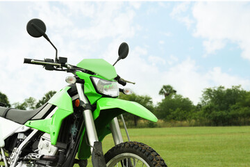 Stylish green cross motorcycle outdoors, space for text