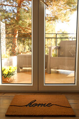 Fototapeta premium Doormat with word Home on parquet floor indoors