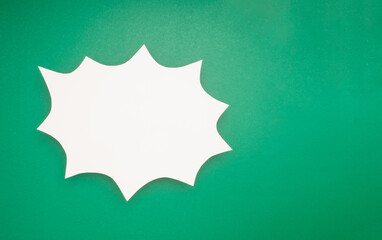 A blank white comic speech bubble on a green background