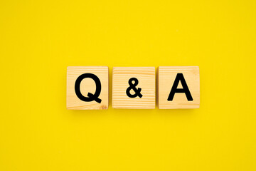 Wooden cubes with words Q and A on a yellow background