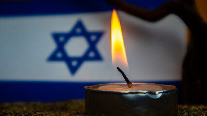 Israeli flag and candles burning in front of it, Holocaust memory day