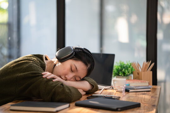 Tired overworked businesswoman sleeping on her laptop exhausted from work. A tired businesswoman fell asleep on a laptop.