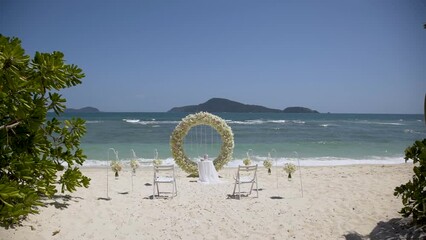 wedding setup flowers chairs. Wedding arch decorated ceremony beach.