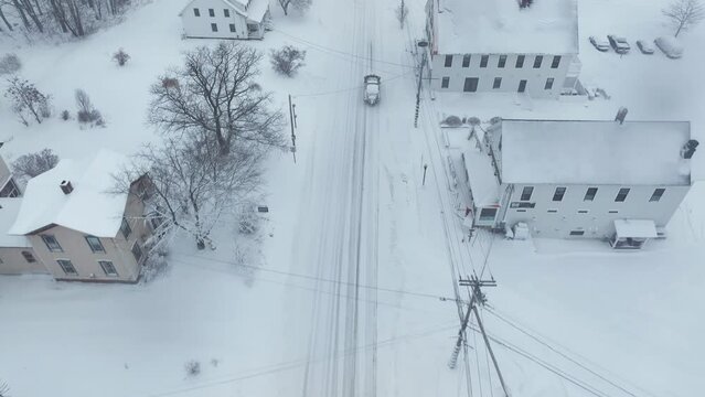 Truck with plow driving through snow-covered Monson Town