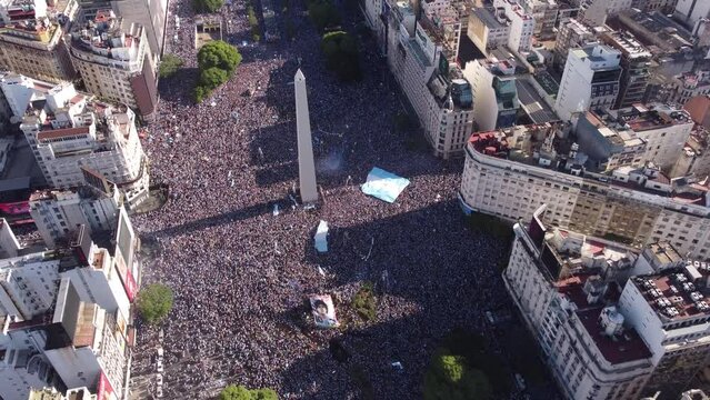 Aerial tilt up shot of million fans celebrating around Obelisk Monument in Buenos Aires after winning world cup in Qatar