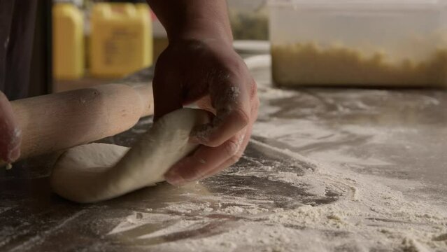 Preparation of the dough for pie, chef rolling dough using roll and flour