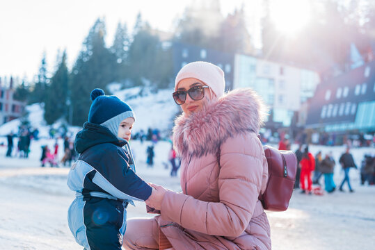 Happy Family On The Winter Holiday Vacation Young Mother And Child Son Having A Fun On Snow Outdoor.