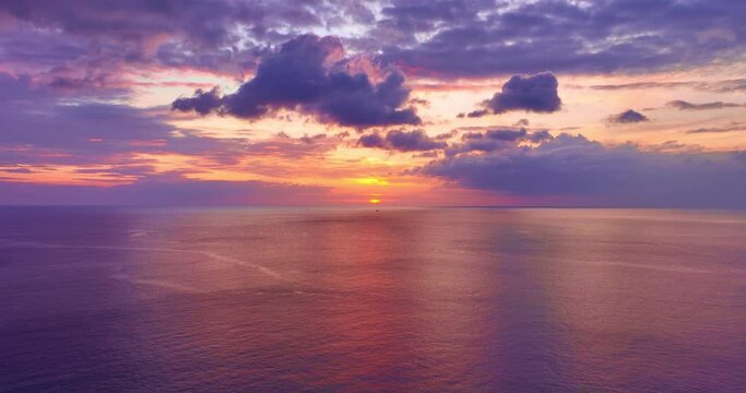 Colorful sunset or sunrise above the sea surface,Aerial view drone fly over open sea,Reflected sun beautiful light of nature on water surface,Sunset over ocean,Sea summer and travel vacation concept