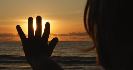 Happy boy in rays of the sun. 4-5 boy silhouette catching sun glare. child Dream concept. Happy child in ocean sunset. Little boy dream and happy memories. Happy child on ocean family travel vacations