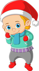 The boy dressed in winter warm clothes and wearing santa hat