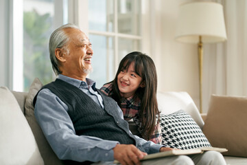 senior asian man having a good time with granddaughter
