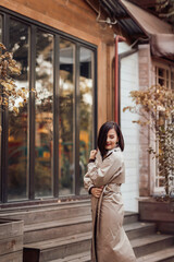 an attractive brunette in an autumn coat on a city street.