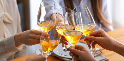 Friends clinking glasses of tasty wine at party, closeup