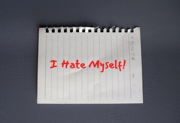Torn note paper on grey background with text written I HATE MYSELF, concept of self hatred...