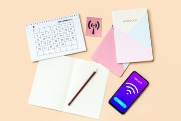 Calendar, stationery supplies and mobile phone with WiFi symbol on color background