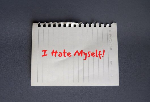 Torn note paper on grey background with text written I HATE MYSELF, concept of self hatred ,negative inner critic which constantly puts down, critical voice compare tell that they are not good enough