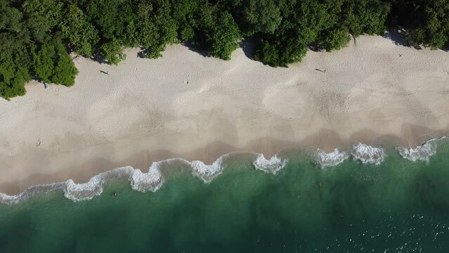 Aerial view of a white sandy beach with crystal clear waters in Costa Rica, Conchal beach.