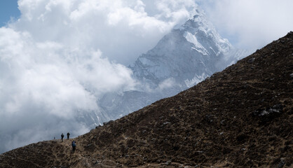 people walk against the backdrop of Mount Ama Dablam in the Himalayas Nepal