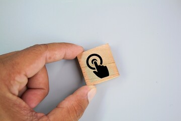 hand holding wooden square with fingerprint or touch screen icon. fingerprint concept. A...