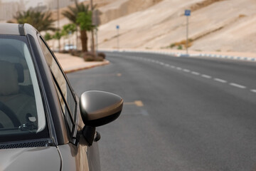 Modern car on road in desert, closeup