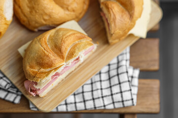 Delicious kaiser rolls with ham and cheese on table