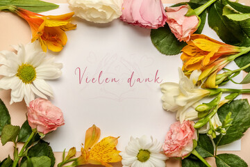 Card with text VIELEN DANK and beautiful flowers, closeup