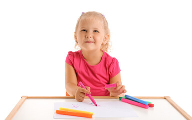 Cute little girl drawing with felt-tip pens at table on white background