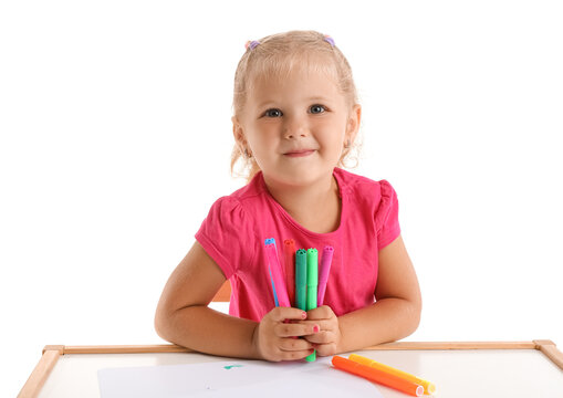 Cute little girl with felt-tip pens at table on white background