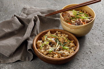 Wooden bowl of rice with vegetables served with chopsticks. Traditional asian food