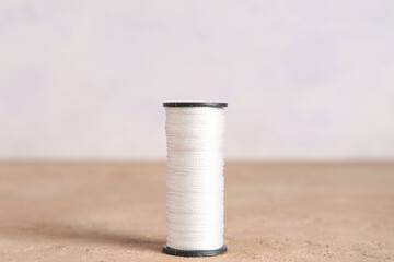 White thread spool on color table